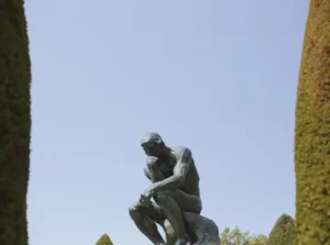 The Thinker (French: Le Penseur), by Auguste Rodin, is a bronze sculpture depicting a nude male figure of heroic size, seated on a large rock, leaning forward, right elbow placed upon the left thigh, back of the right hand supporting the chin in a posture evocative of deep thought and contemplation.